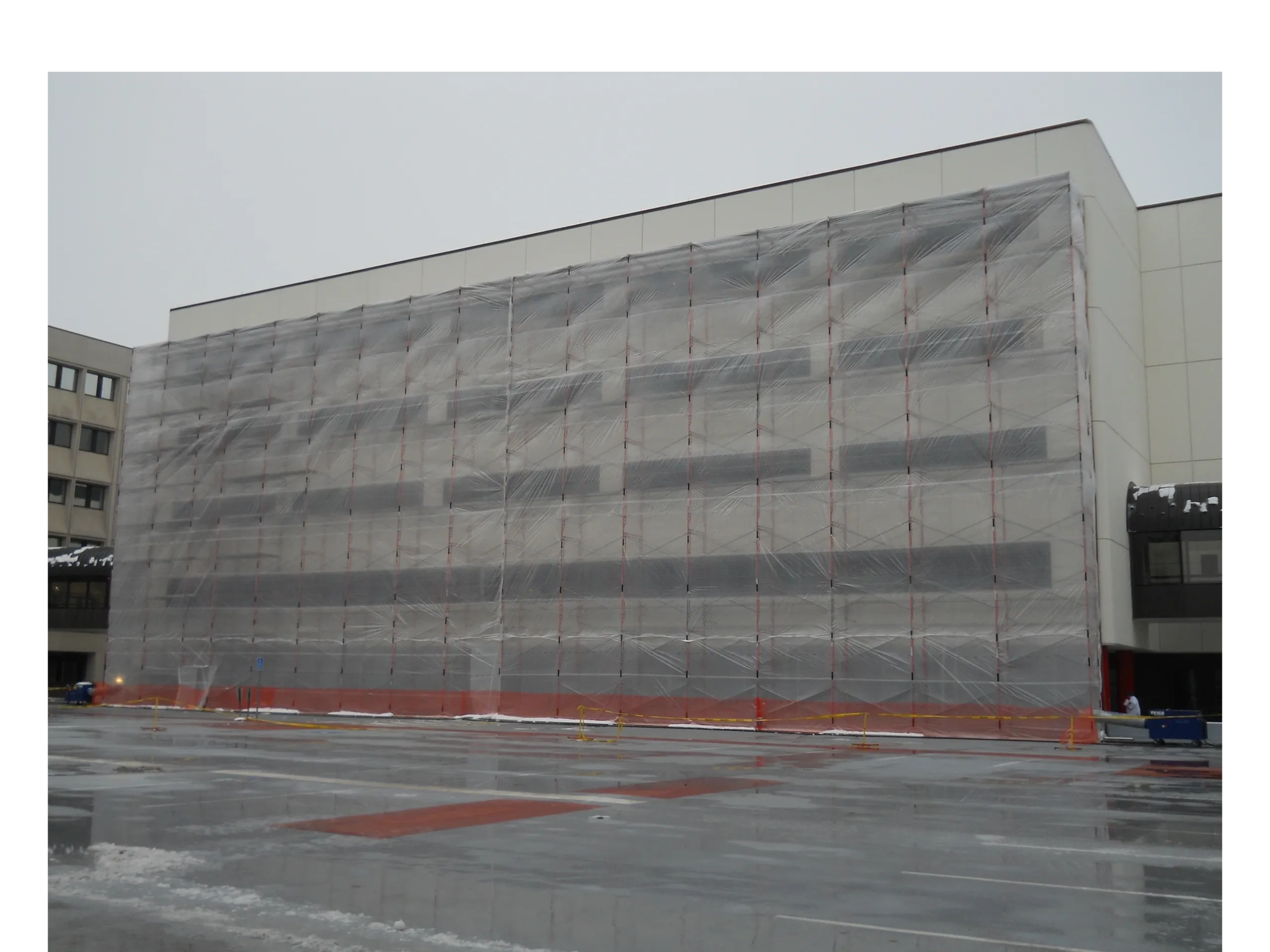 Full scaffold enclosure covering a building under construction